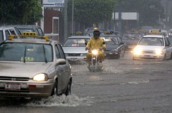 A man rides his motorcycle through a flooded street due to heavy rain in Managua October 6, 2008. Authorities in Nicaragua declared a state of alert along the country���s Pacific coast after days of heavy rain. REUTERS/Oswaldo Rivas (NICARAGUA)