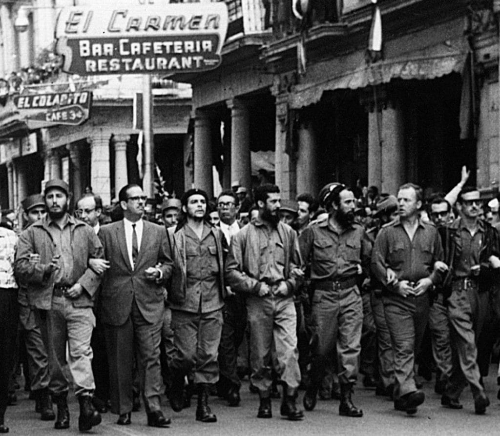 5 de marzo de 1960, líderes cubanos caminan tomados de los brazos al frente de una procesión fúnebre por las víctimas de la explosión del buque cubano La Coubre